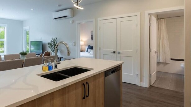 A modern kitchen with a central island, a dishwasher, and pendant lighting. - Cosmo’s Getaway | Mtn Views | AC | BBQ | King Bed (Golden)