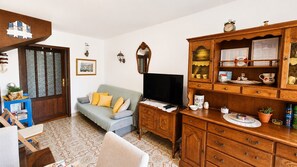 A living room with a sofa, television, wooden cabinet, and patterned floor. - Small semi-detached house Radojevic for 4-5 persons (Baska)