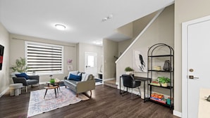 A modern living room with a sofa, coffee table, and a bookshelf.