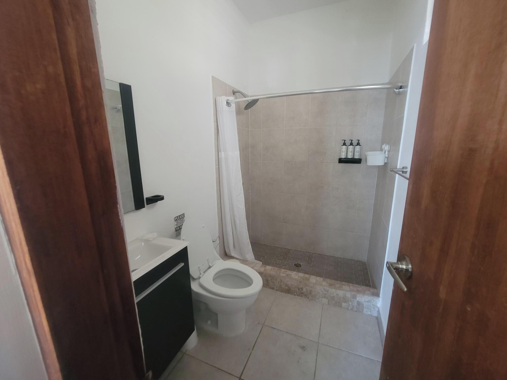 A bathroom with a toilet, sink, and shower area.