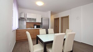 A compact kitchen with a dining table and chairs, a refrigerator, and a microwave. - Apartment Smojver No.4 - comfortable, with Balcony (Baska)