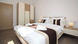 Ein Hotelzimmer mit Bett, Nachttischen, einem Kleiderschrank und einer Tür.