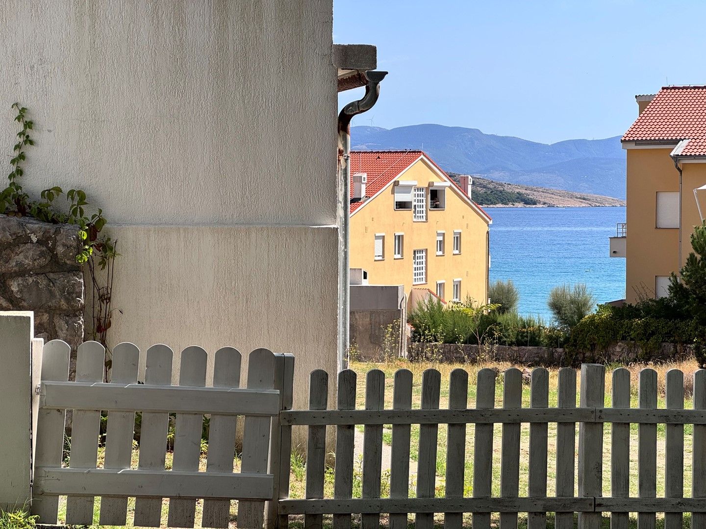A coastal building with a view of the sea and mountains.
