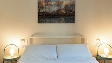 Ein Schlafzimmer mit einem Bett, zwei Nachttischen mit Lampen und einem Gemälde an der Wand.
