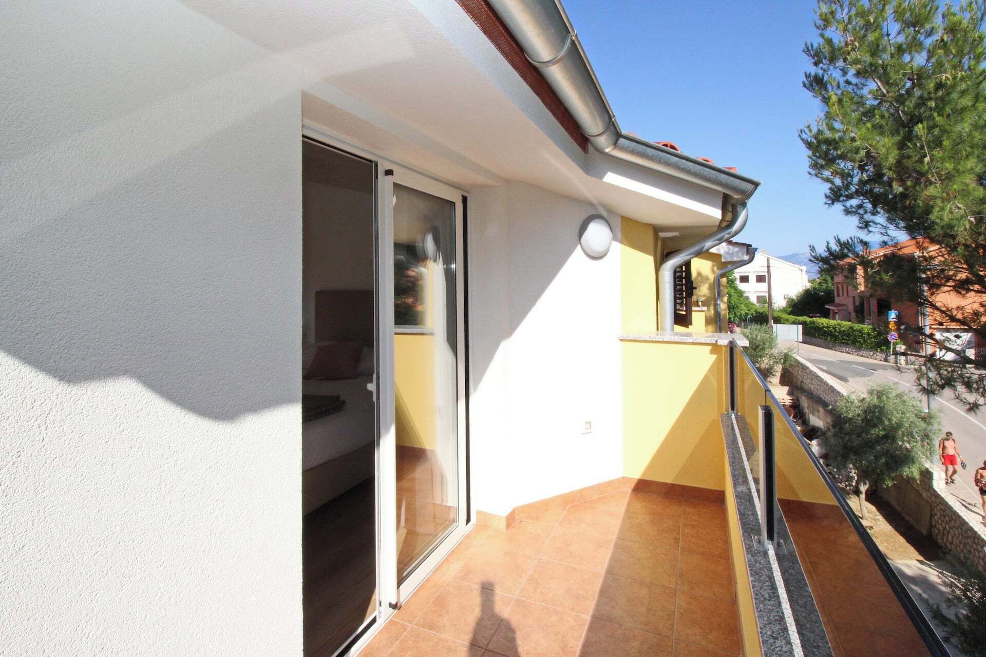 A residential building with a sliding glass door leading to a balcony.