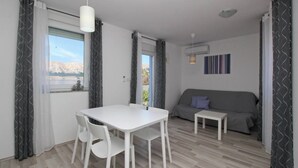 Un espace de vie compact comprenant une table et des chaises, un canapé et une petite table d’appoint.