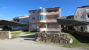 A multi-story building with a curved facade, stone walls, and outdoor seating areas. - Apartment Mrakovcic No.1 - with Terrace, 350 m from the Beach (Baska)
