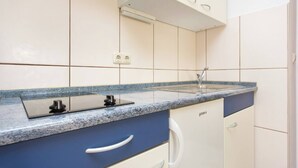 A kitchen with a granite countertop, a double sink, and white cabinets. - Apartment Mrakovcic No.4 - with Balcony, 350 m from the Beach (Baska)