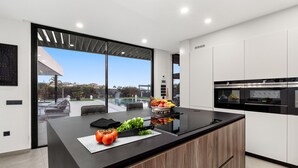 A modern kitchen with a large island, black countertop, and wooden cabinets. - Atlantic Silent Heights Villa (Adeje)