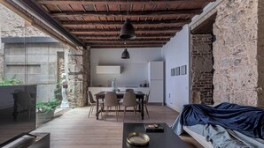 Un interior acogedor con una mesa de comedor de madera, un sofá y una zona de cocina.