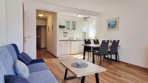 Eine moderne Wohnung mit Wohnbereich, Esstisch und Küchenzeile.
