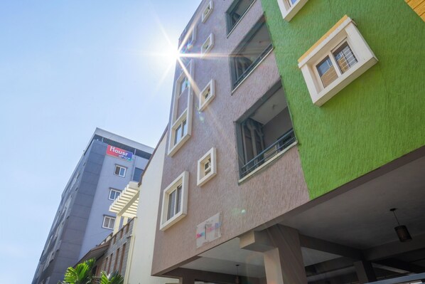 A multi-story building with a sign indicating it is a hotel. - Housr Ferguson Apartment Near Radisson (Bengaluru)