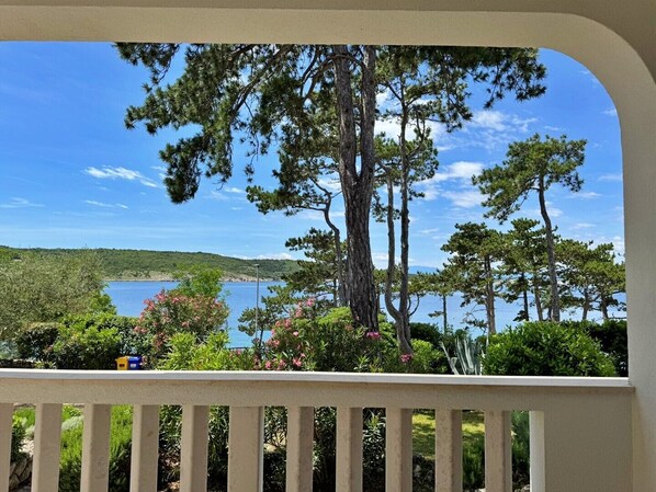 A balcony with a view of a lake and trees.