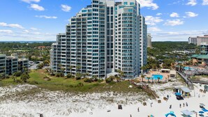 Ein Hochhotel mit mehreren Etagen, einem Poolbereich und Blick auf den Strand.