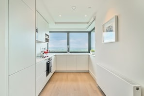 Apartamento, 2 quartos | Cozinha privada | Geladeira grande, micro-ondas, fogão, cooktop