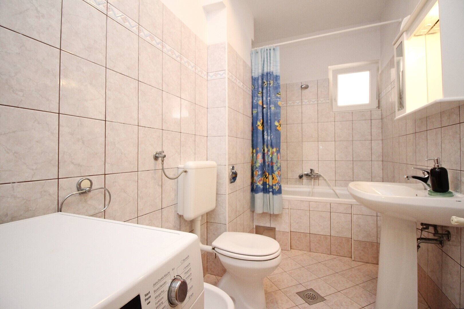 Uma casa de banho com sanita, lavatório e banheira.