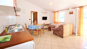 A compact living space with a kitchen, dining area, and a sofa.