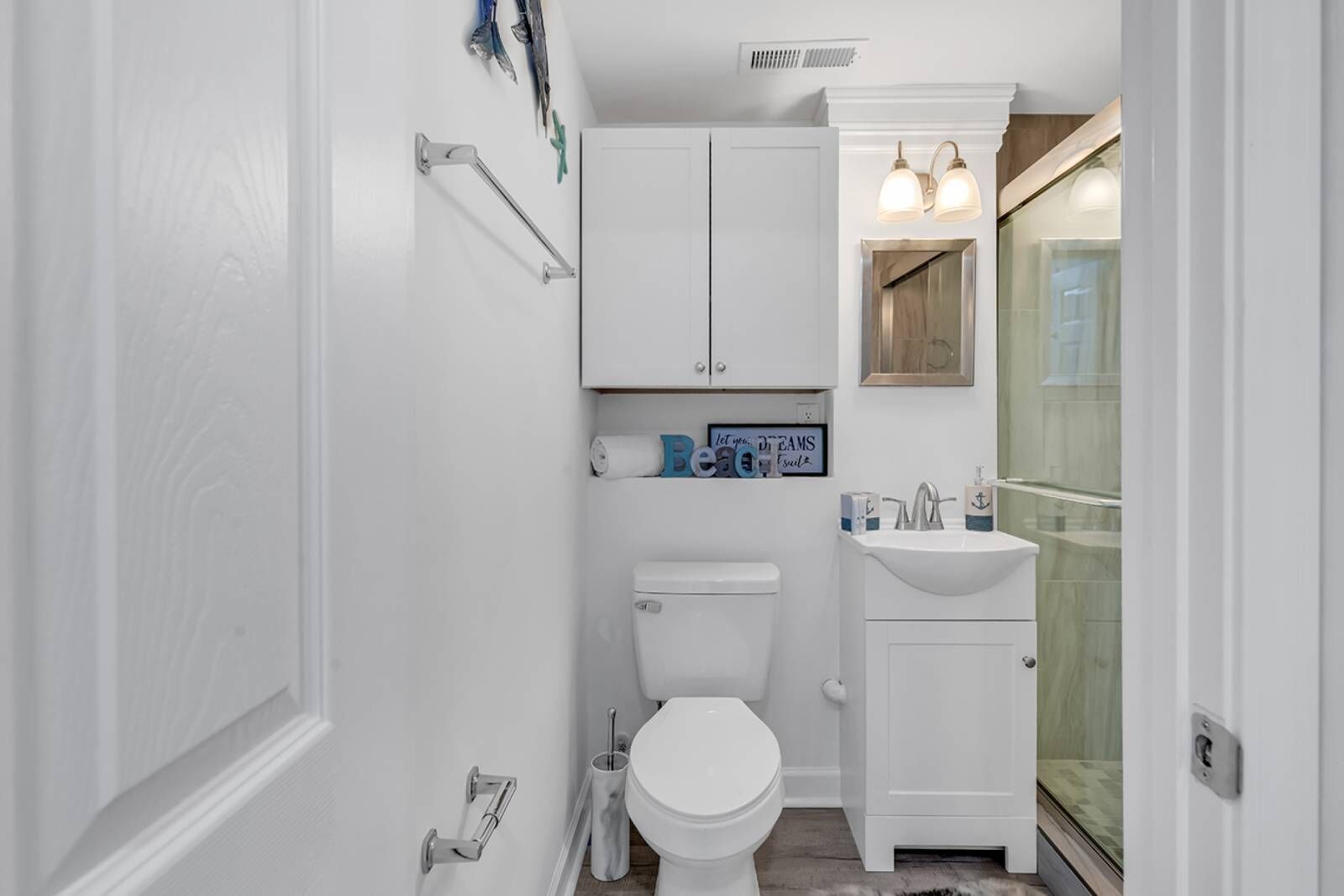 A compact bathroom with a toilet, a sink, and a shower.