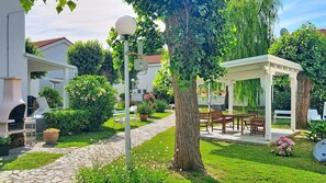 Ein Garten mit einem Gartenhaus, Sitzmöglichkeiten im Freien und einem Kiesweg.
