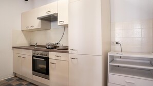 Eine kleine Küche mit Herd, Backofen und Arbeitsfläche.