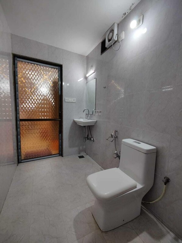 A modern bathroom with a toilet, sink, and shower.