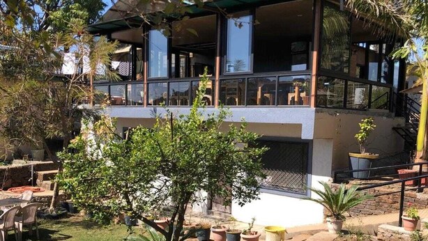 A modern building with a balcony overlooking a landscaped garden. - Aditya Forest Eco Resort (Abu Road)