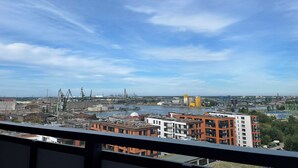 Un paisaje urbano con edificios modernos, un río y grúas industriales.