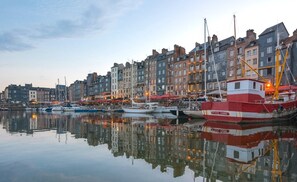 Une promenade en bord de mer bordée d’une rangée de bâtiments colorés et de bateaux amarrés le long de la rive.