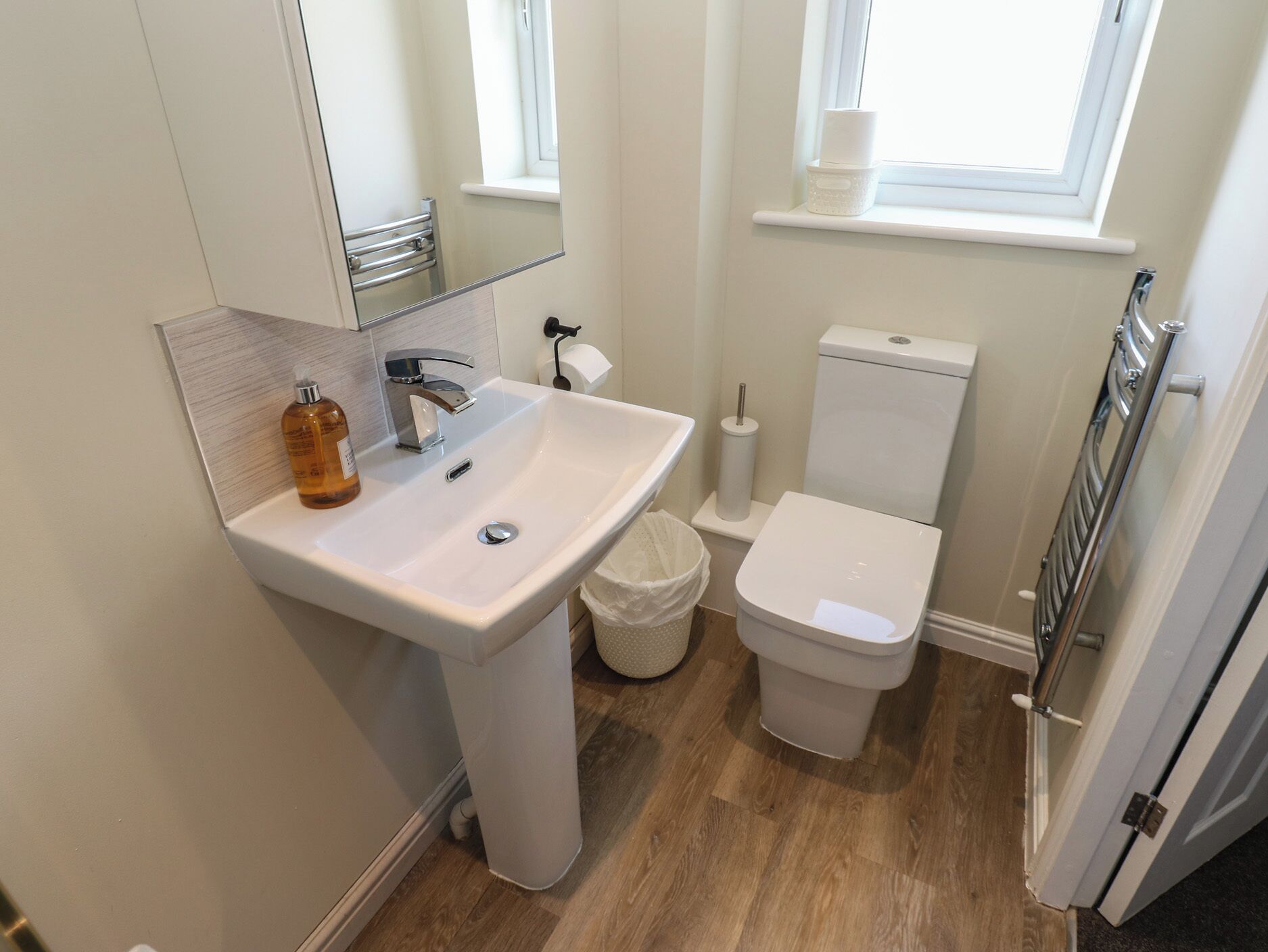 A bathroom with a white sink, a toilet, and a window.