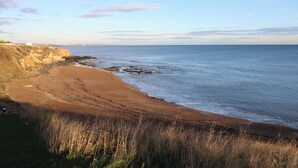 A coastal beach with a rocky shoreline and a clear sky. - 5 Ashcroft Mews (Seaham)