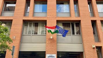 Un edificio de ladrillo con un letrero que dice “Urban Nest” y una bandera sobre la entrada.