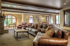 Relax in this inviting living room with a comfortable sofa, stone fireplace, and dining area.