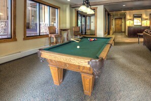 Enjoy a game of pool in our spacious room with a pool table, comfortable seating, and large windows.