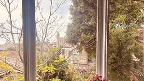 Una ventana con vista a una zona residencial, con casas y árboles.