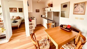 Un espacio compacto con kitchenette, comedor y dormitorio.