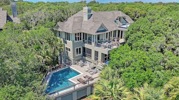 A large, multi-story house with a swimming pool, surrounded by dense greenery. - Oceanfront, private boardwalk and pool (Kiawah Island)