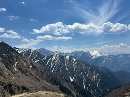 Un paisaje montañoso con picos nevados y cielo despejado.