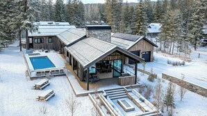 Une cabane moderne dotée d’une piscine, d’un espace salon extérieur et d’une terrasse.