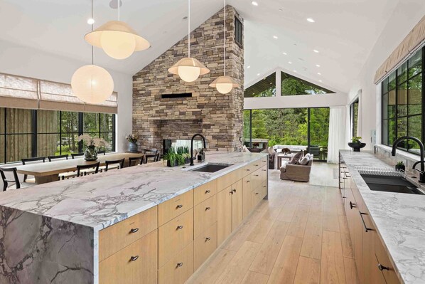 Una cocina moderna con chimenea de piedra, armarios de madera y una isla grande.