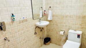 A bathroom with a white sink, a toilet, a mirror, and a hand dryer. - Corbett Hideaway Dada 'S (Ramnagar)