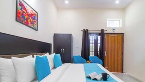 A hotel room with a large bed, a wardrobe, a desk, and a window with curtains. - Corbett Hideaway Dada 'S (Ramnagar)
