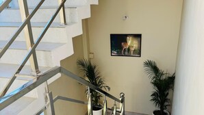 A staircase with metal railings leading to an upper floor. There are potted plants on the landing. - Corbett Hideaway Dada 'S (Ramnagar)