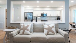 Una cocina moderna con armarios blancos, electrodomésticos de acero inoxidable y una isla central.