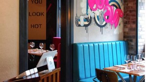 A restaurant interior with a blue booth seating area, a sign reading "NO RIFE RAFF," and a wall with graffiti art. - 1st Floor, One Bed Apt & garden, Scottish Borders (Innerleithen)