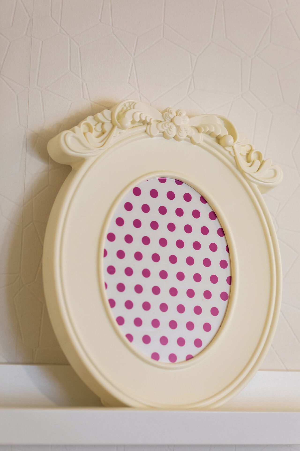 A decorative picture frame with a polka dot design.