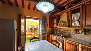 A kitchen with wooden cabinets, a marble countertop, a stove, and a refrigerator. - Amazing home in Cortona (Cortona)