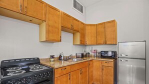 A kitchen with wooden cabinets, a stainless steel refrigerator, a stove, and a microwave. - 1 BR Large Desert ADU Retreat with Bocce Court (Bermuda Dunes)