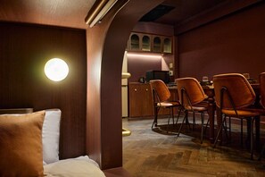 A cozy room with a bed, a round table, and several chairs. - Gold Stage TENJIN (Fukuoka)