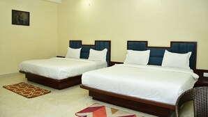 A hotel room with two beds, a small rug, and a chair. - Jai Vilas Palace & Resort (Pali)