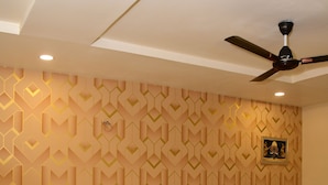 A neatly made bed with white linens, a dark headboard, and a ceiling fan. - Jai Vilas Palace & Resort (Pali)
